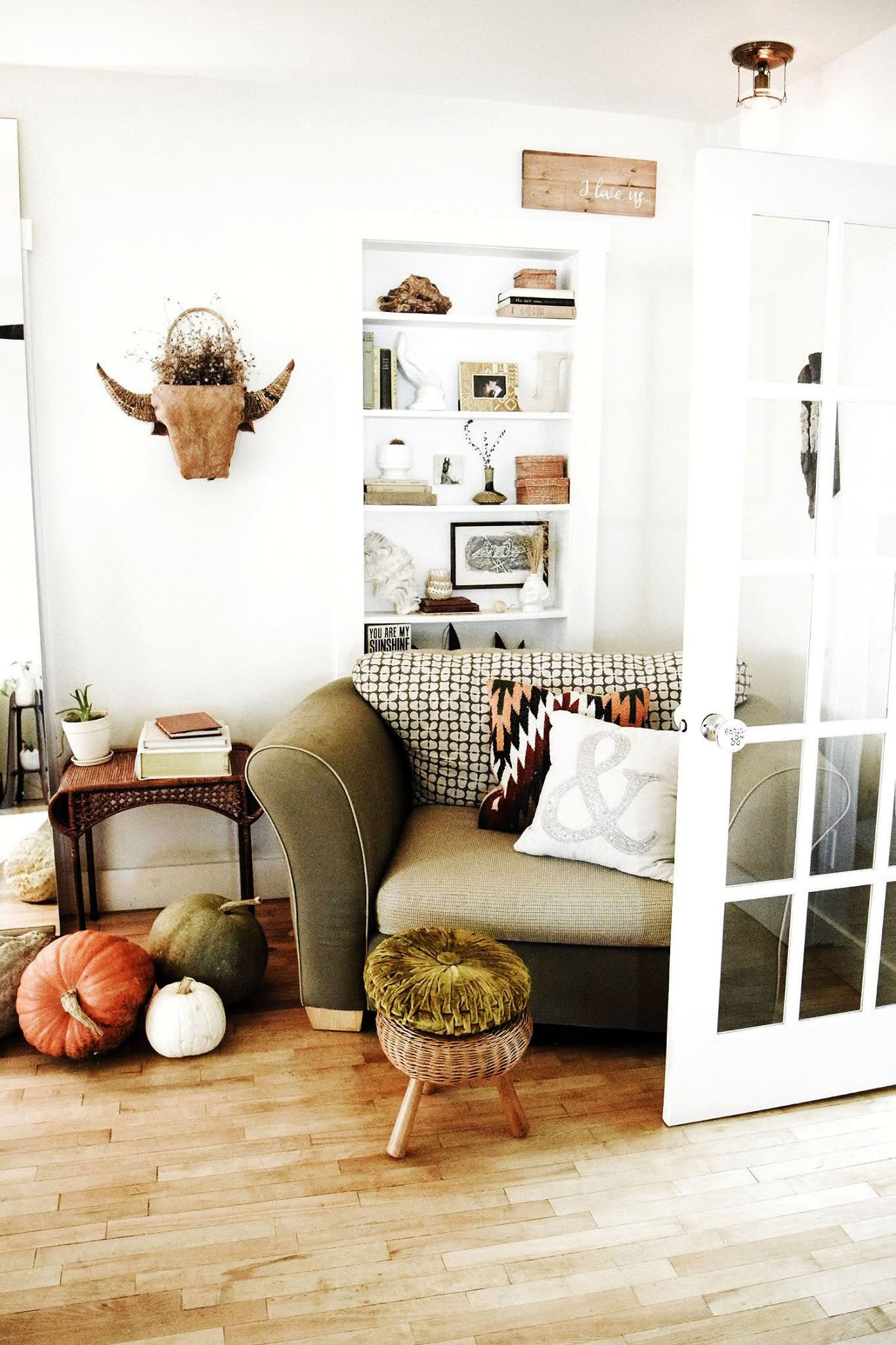 A living room with a couch and pumpkins on the floor