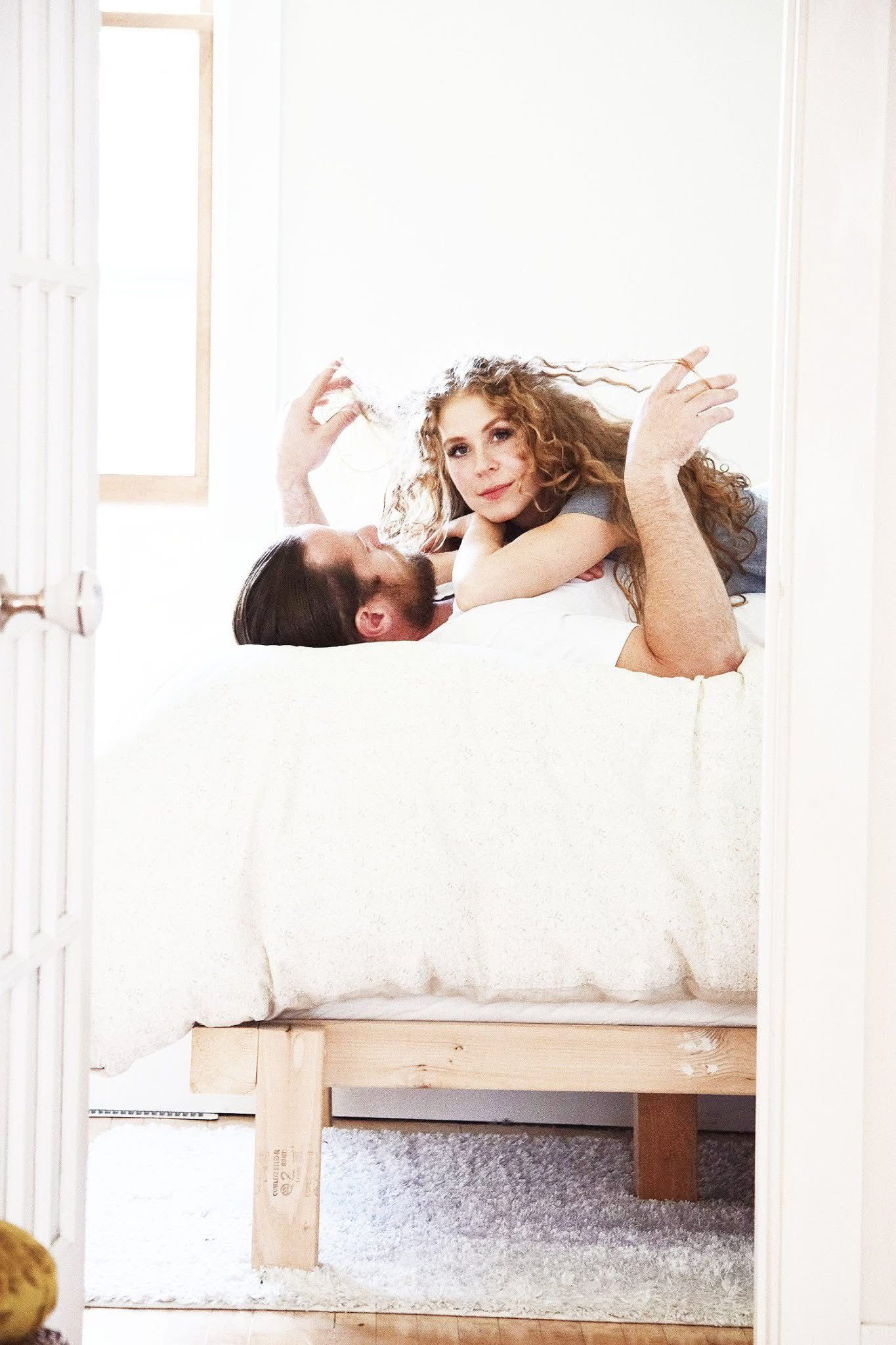 A man and a woman are laying on a bed.