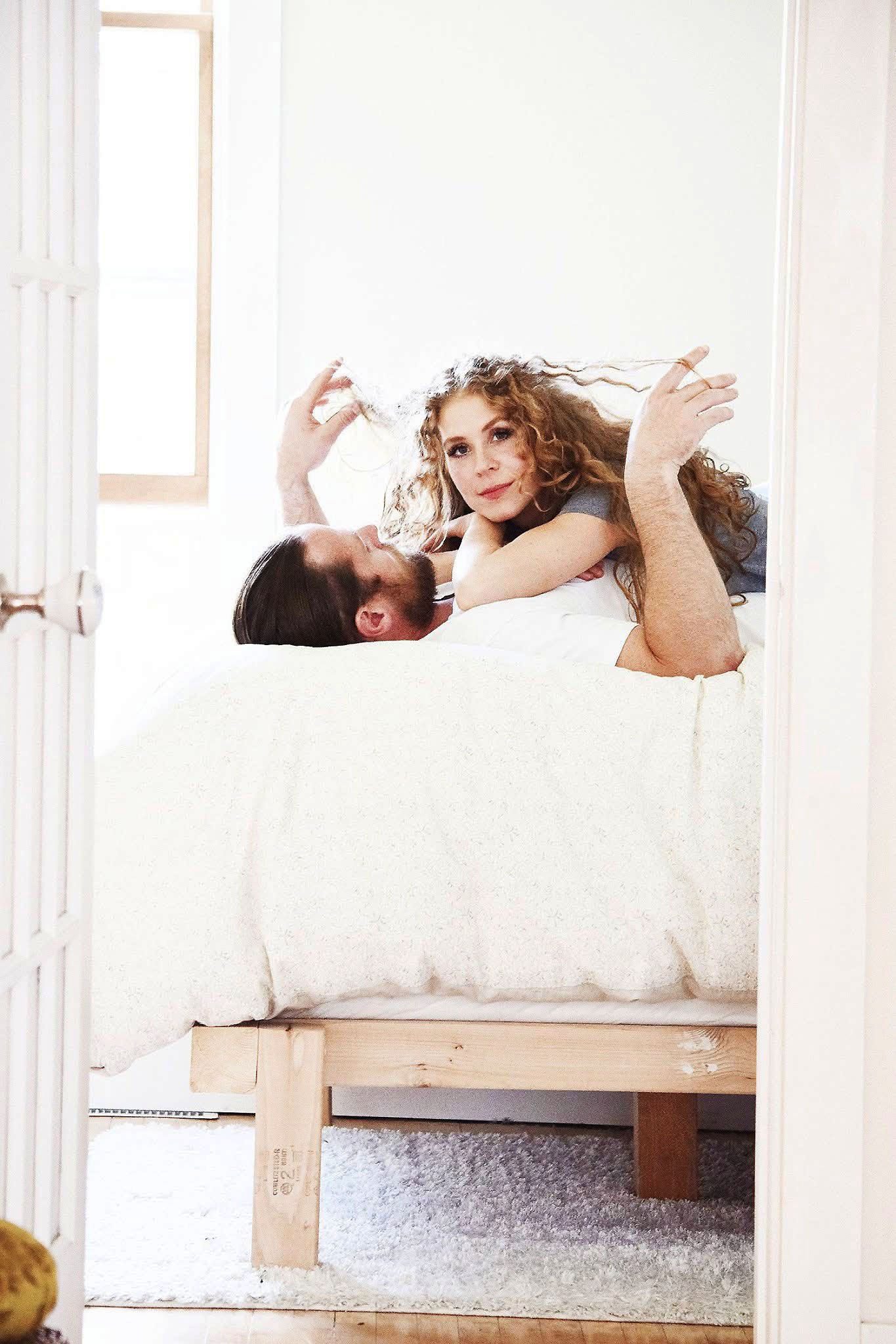 A man and a woman are laying on a bed.