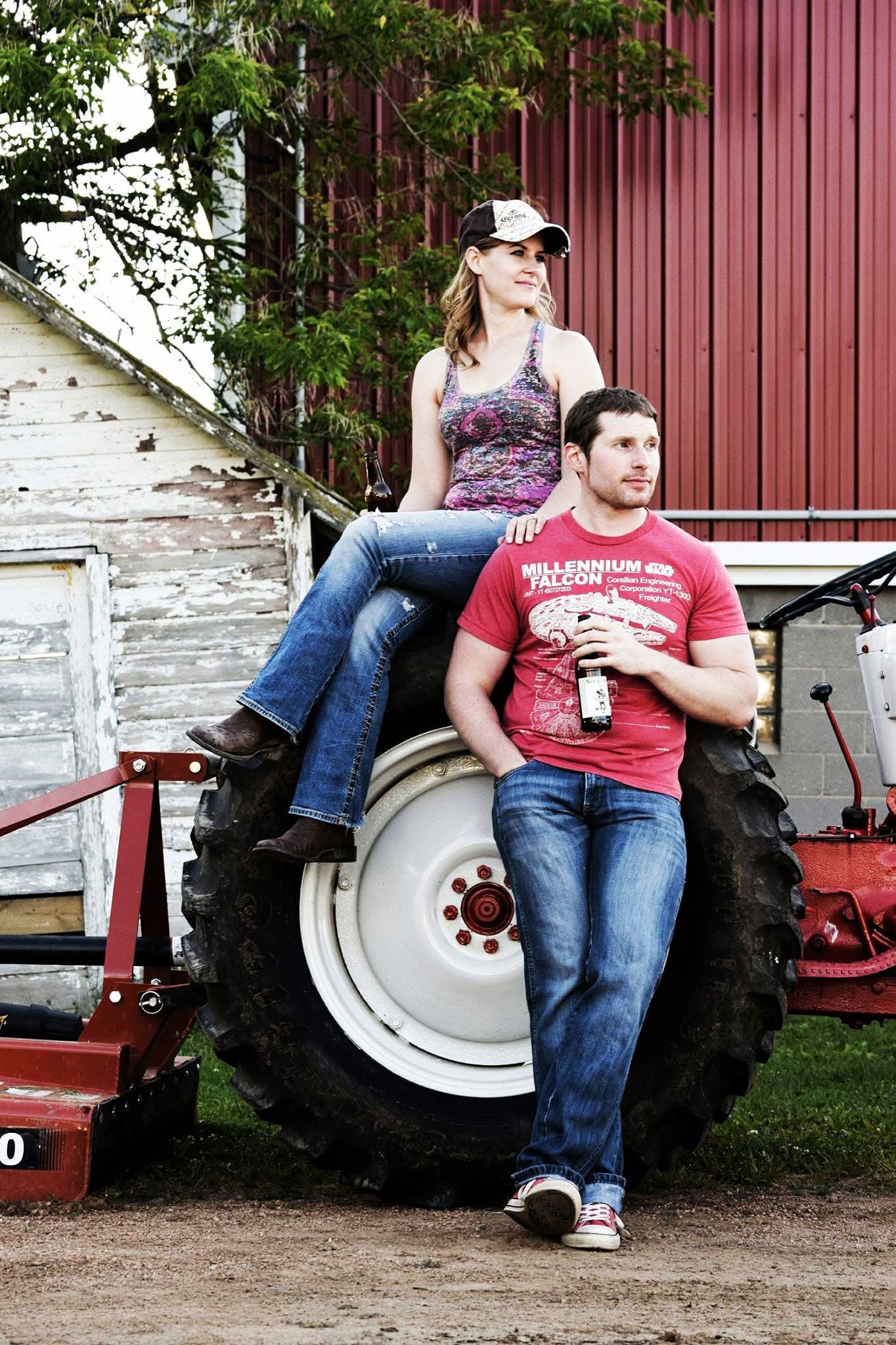 A man and a woman sitting on a tractor tire