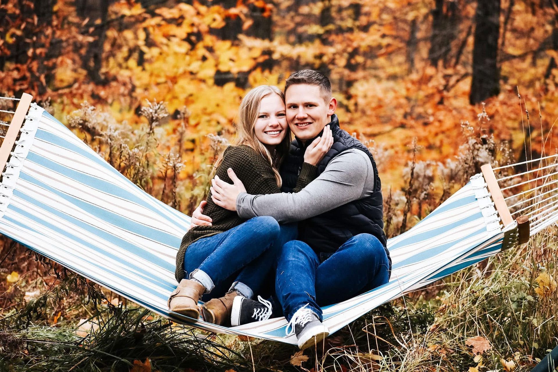 A man and a woman are sitting in a hammock.