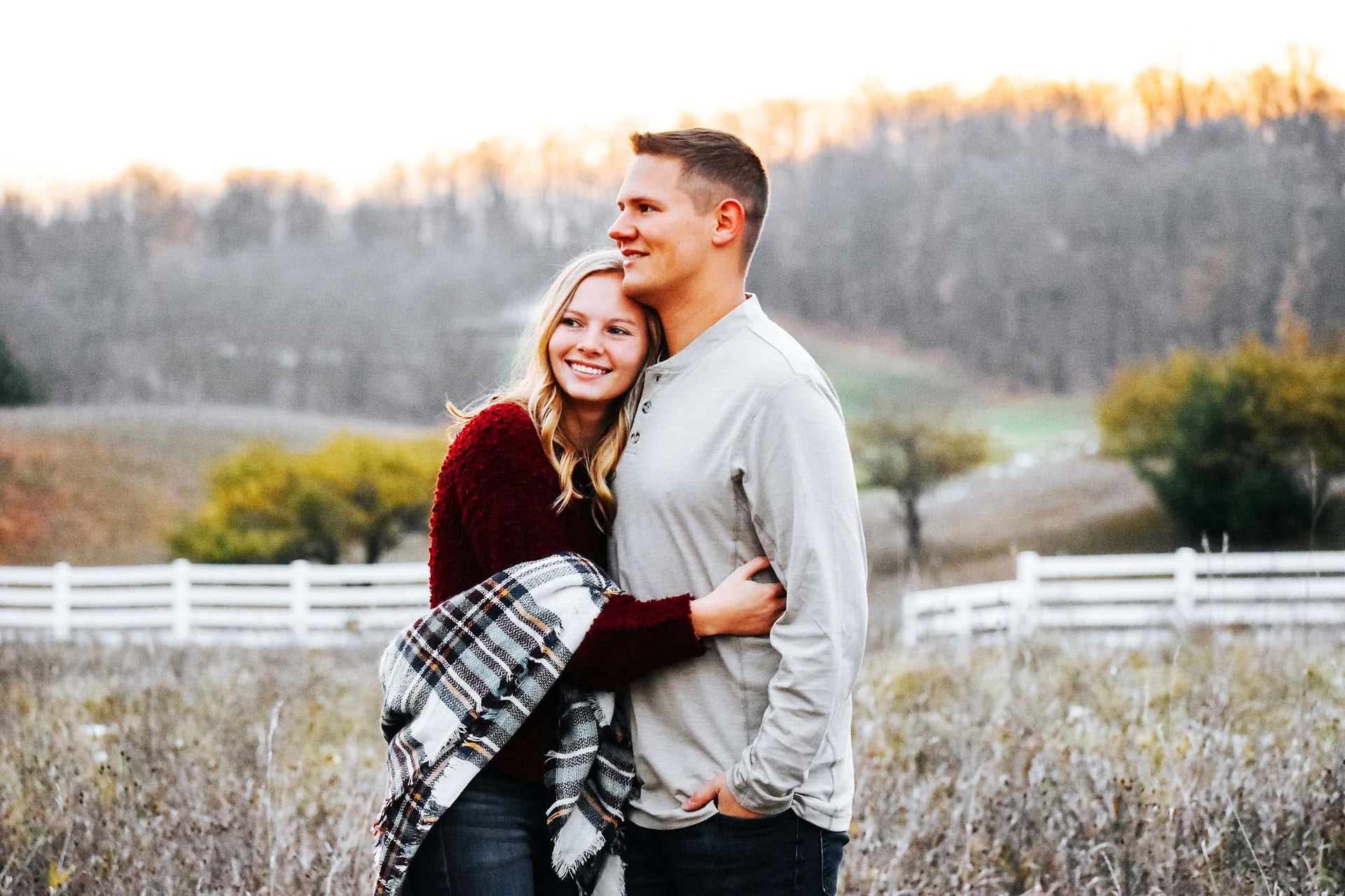 A man and a woman are standing next to each other in a field.