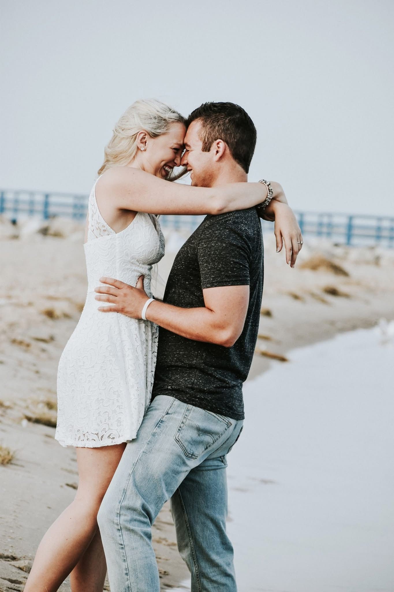 A man and a woman are hugging on the beach.