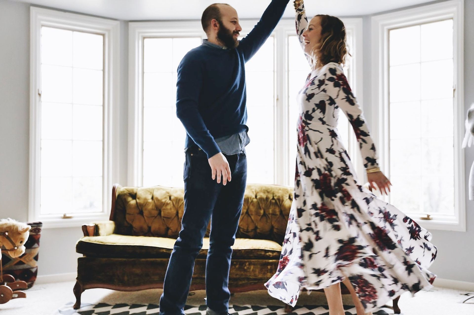 A man and a woman are dancing in a living room.