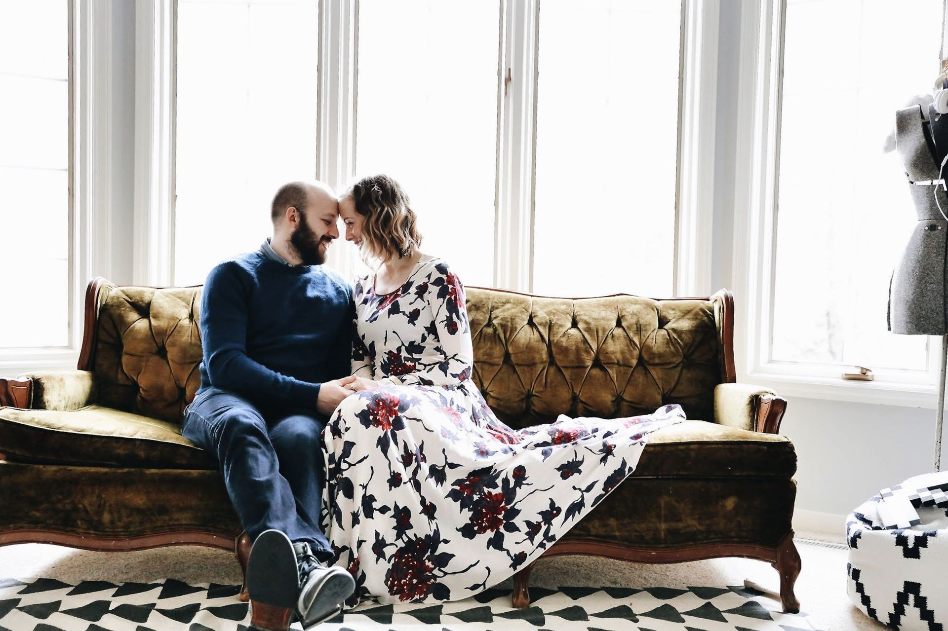 A man and a woman are sitting on a couch looking at each other.