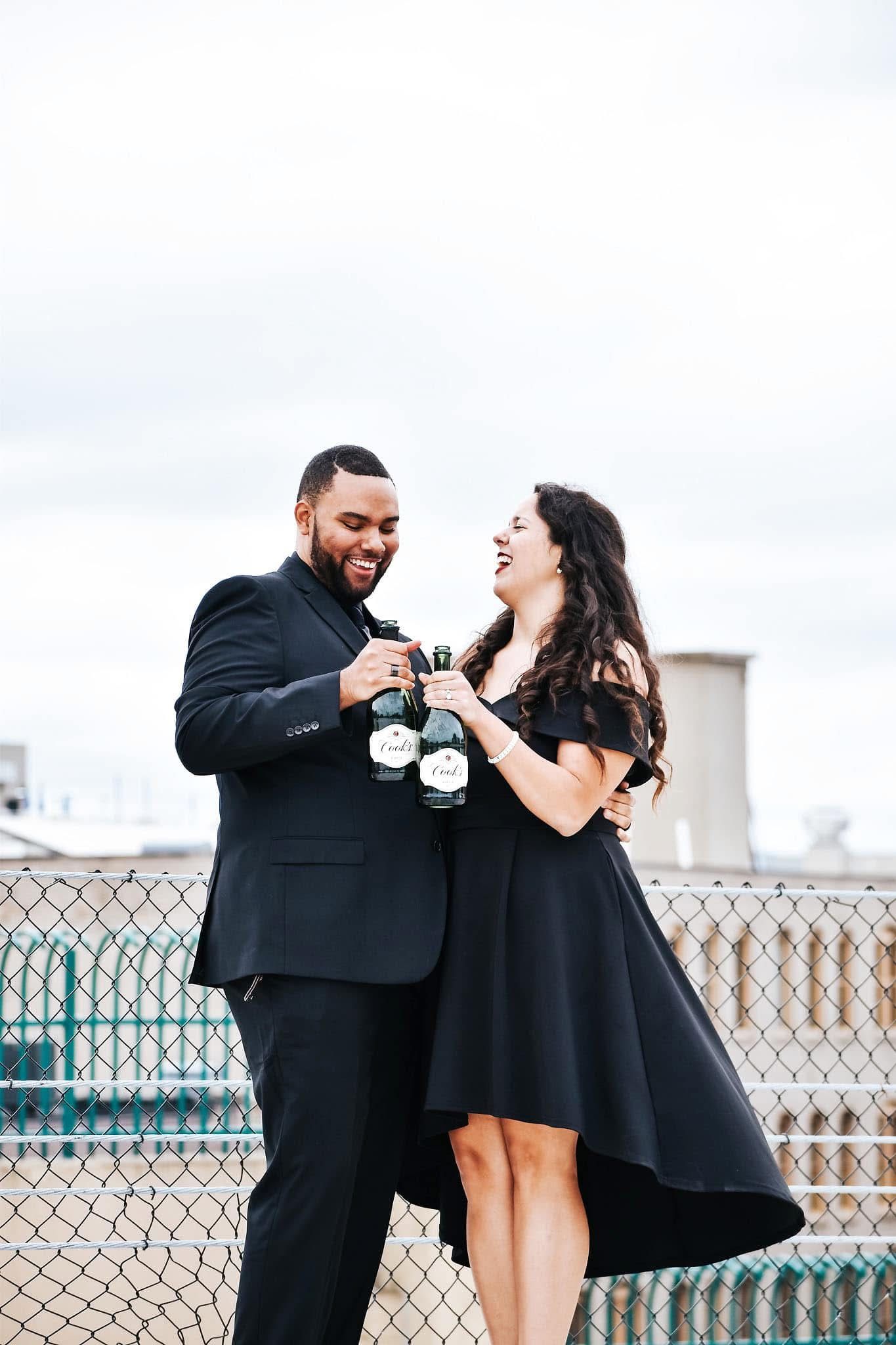 A man and a woman are toasting with champagne on a balcony.