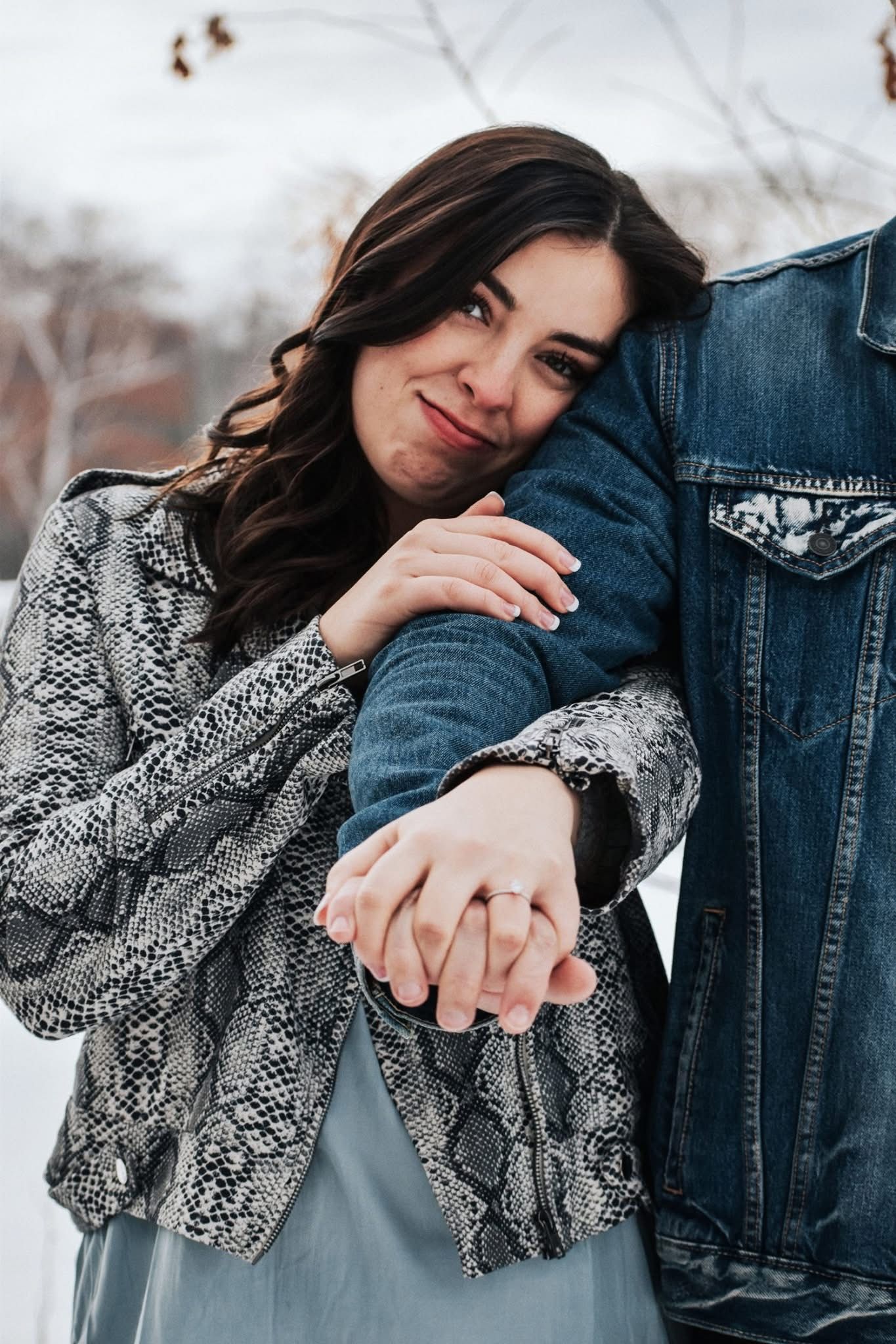 A man and a woman are holding hands in the snow.