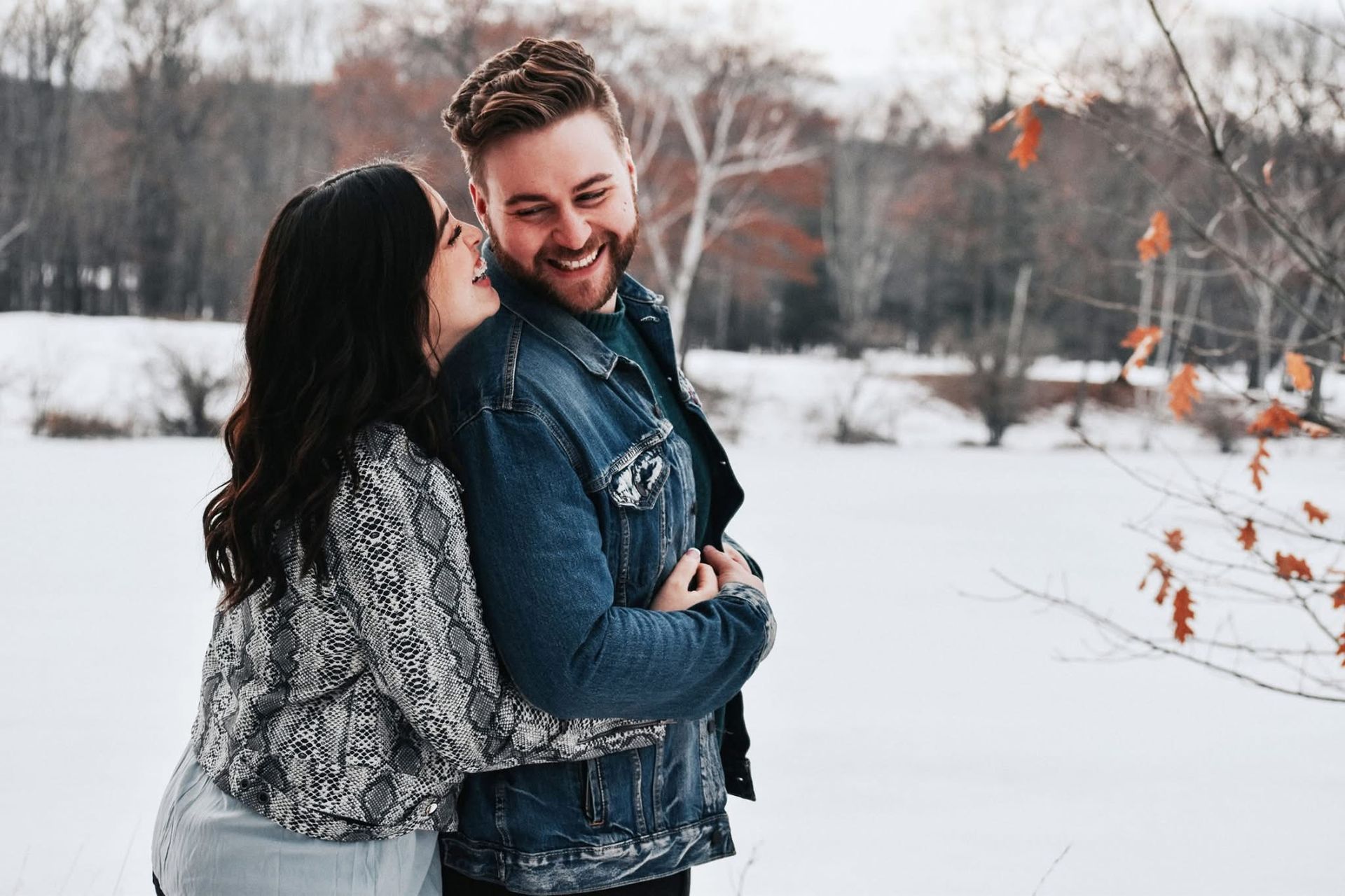 A man and a woman are hugging in the snow.