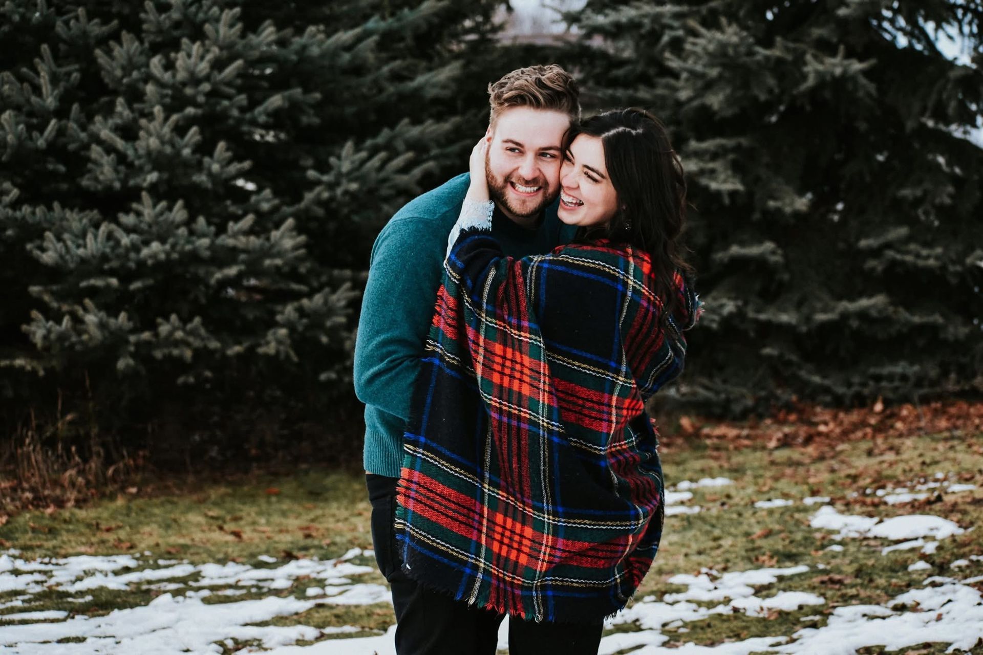 A man is holding a woman in his arms in the snow.