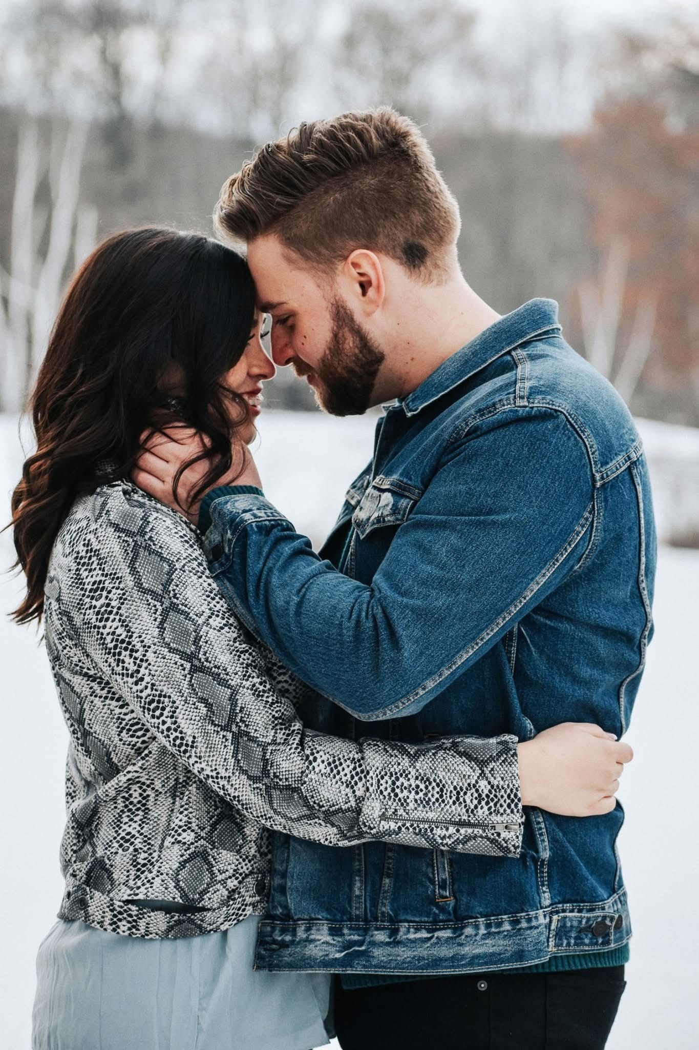 A man and a woman are hugging each other in the snow.