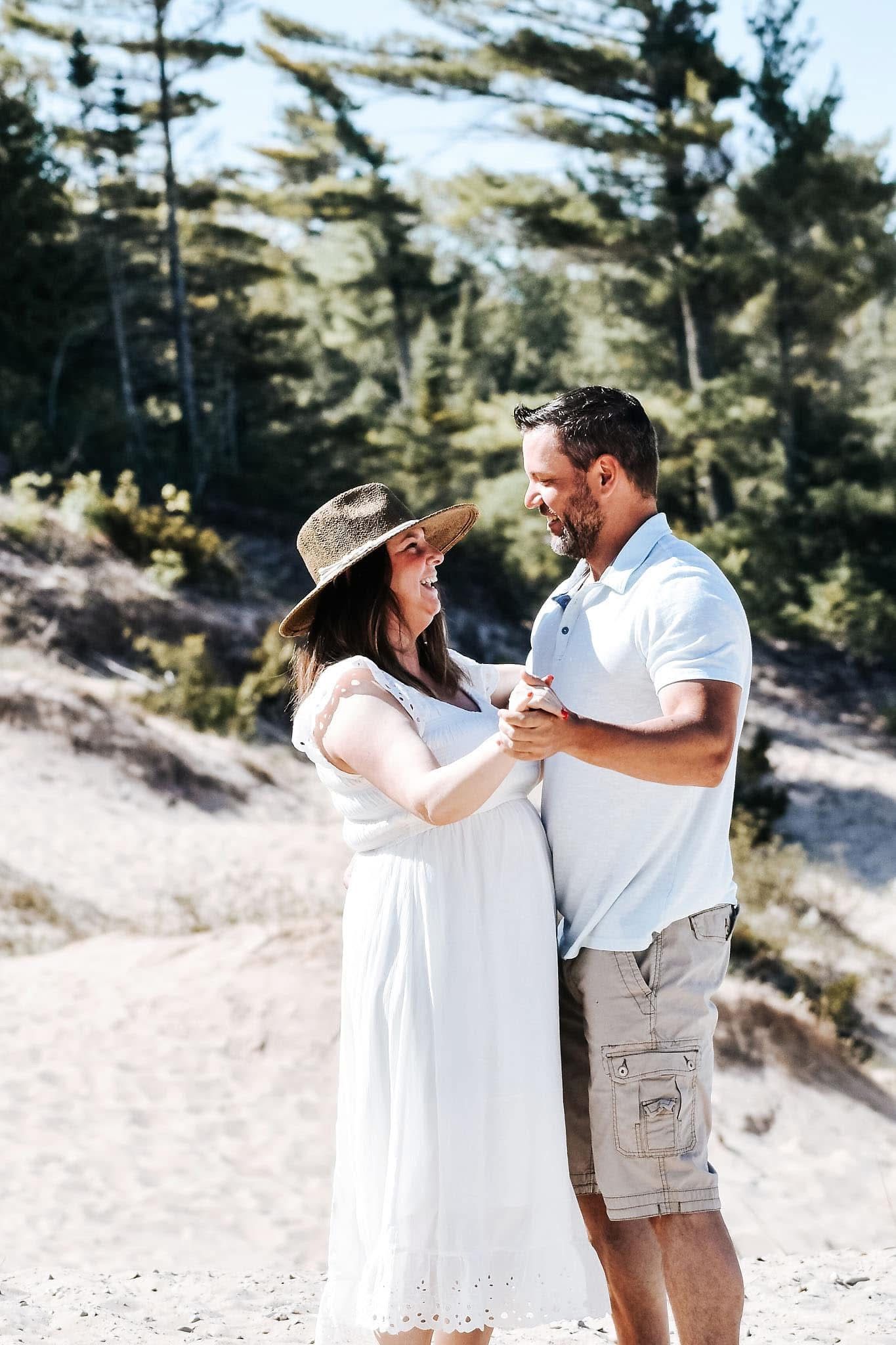 A man and a woman are standing next to each other on a beach.