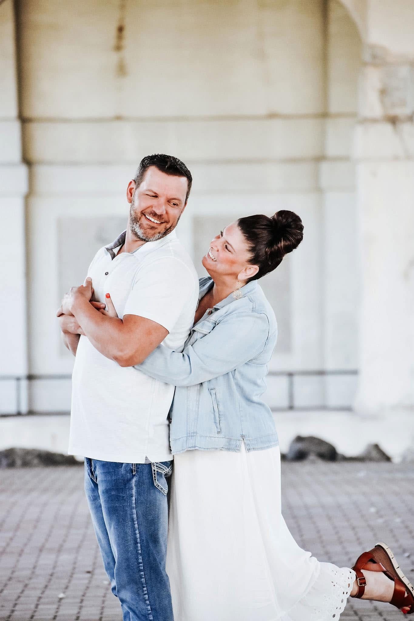 A man and a woman are dancing together in front of a building.
