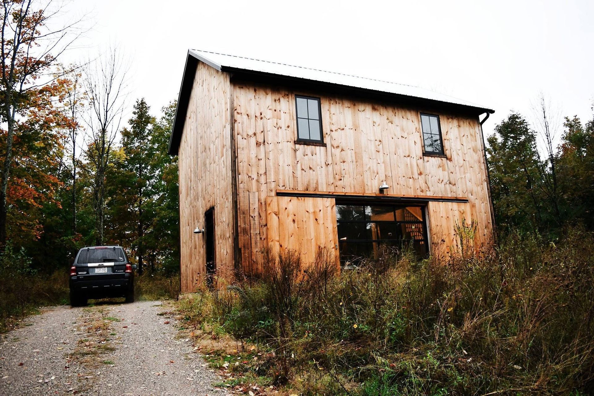 A car is parked in front of a wooden building