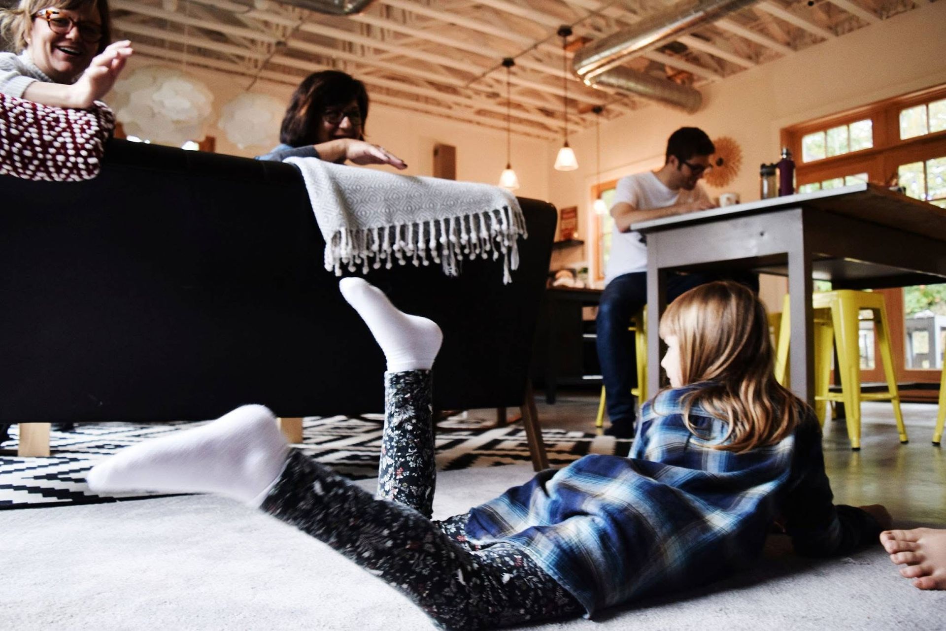 A little girl is laying on the floor in a living room.