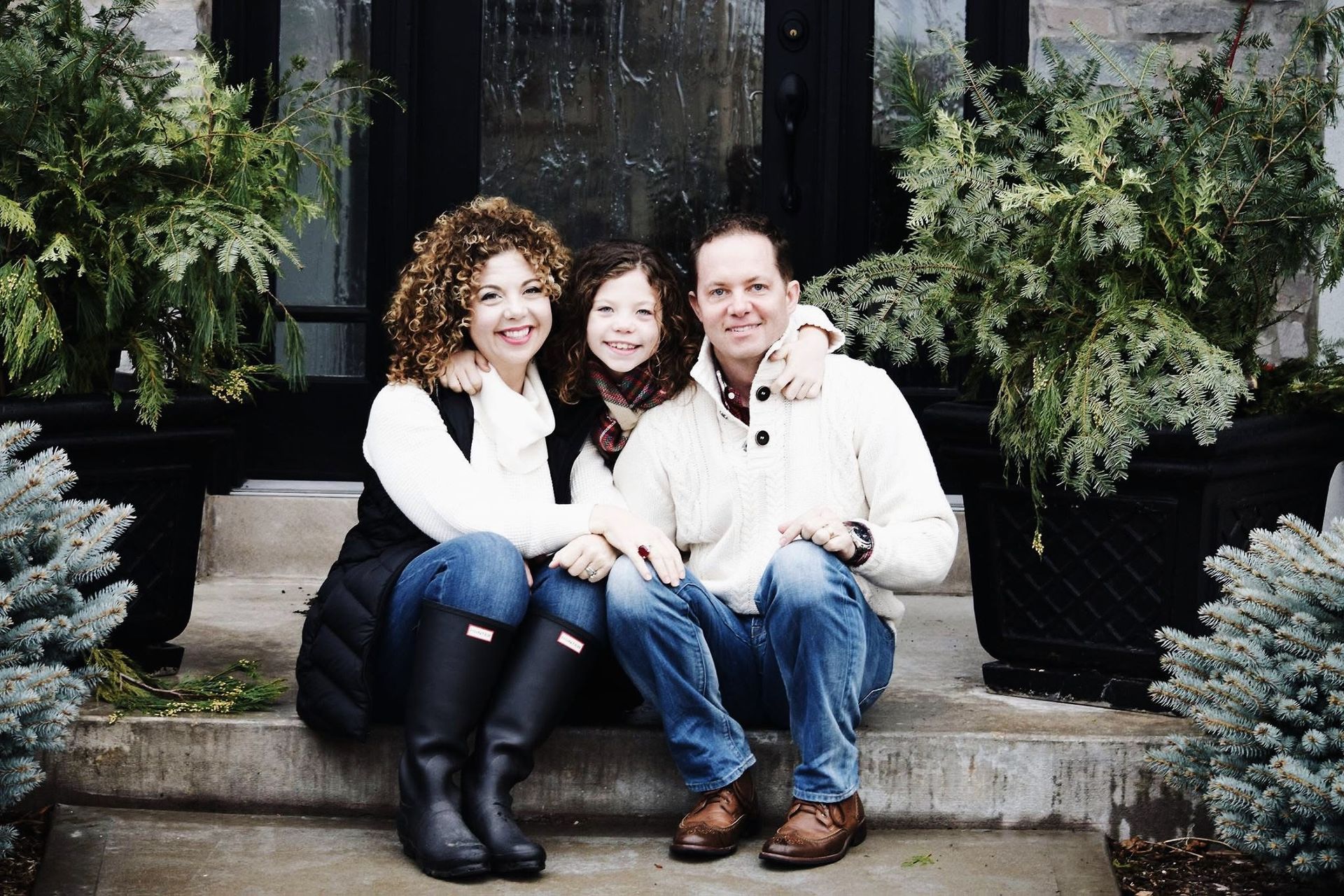 A family is posing for a picture on the steps of their house