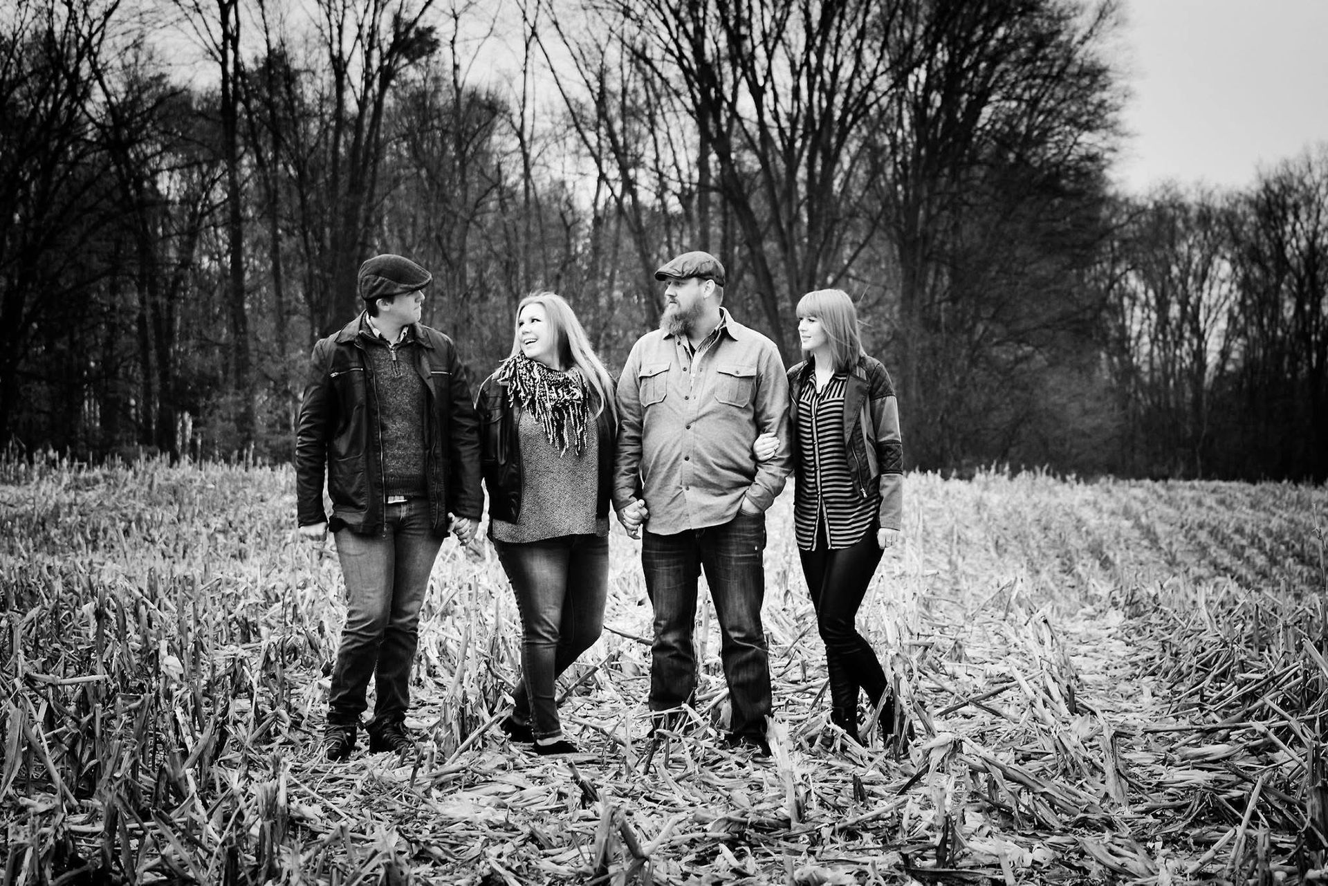 A group of people are standing in a field in a black and white photo.