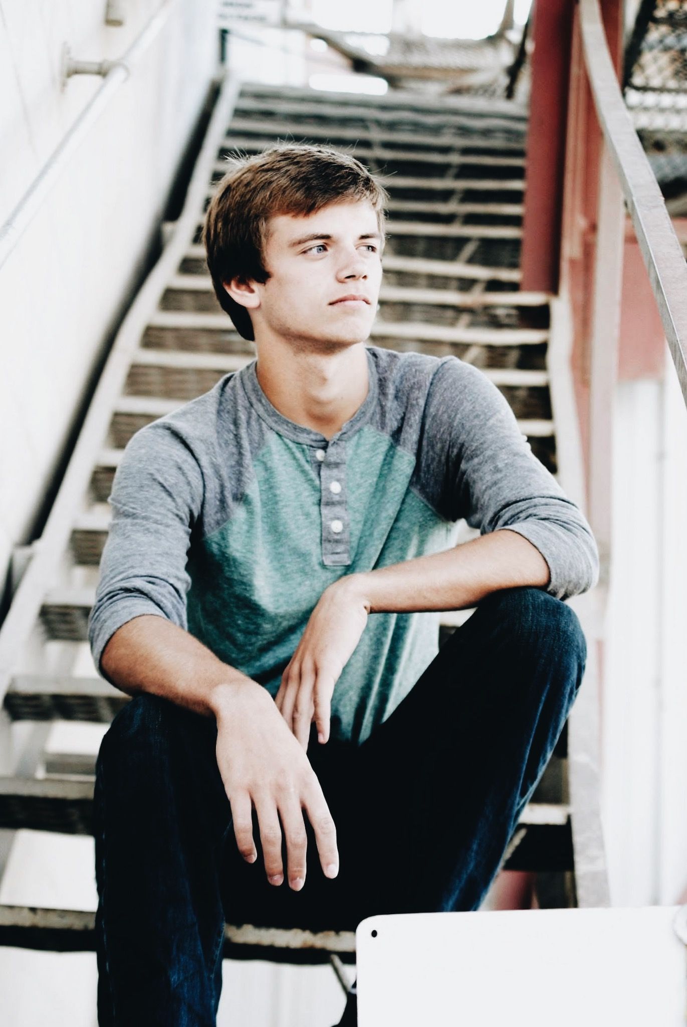 A young man is sitting on a set of stairs.