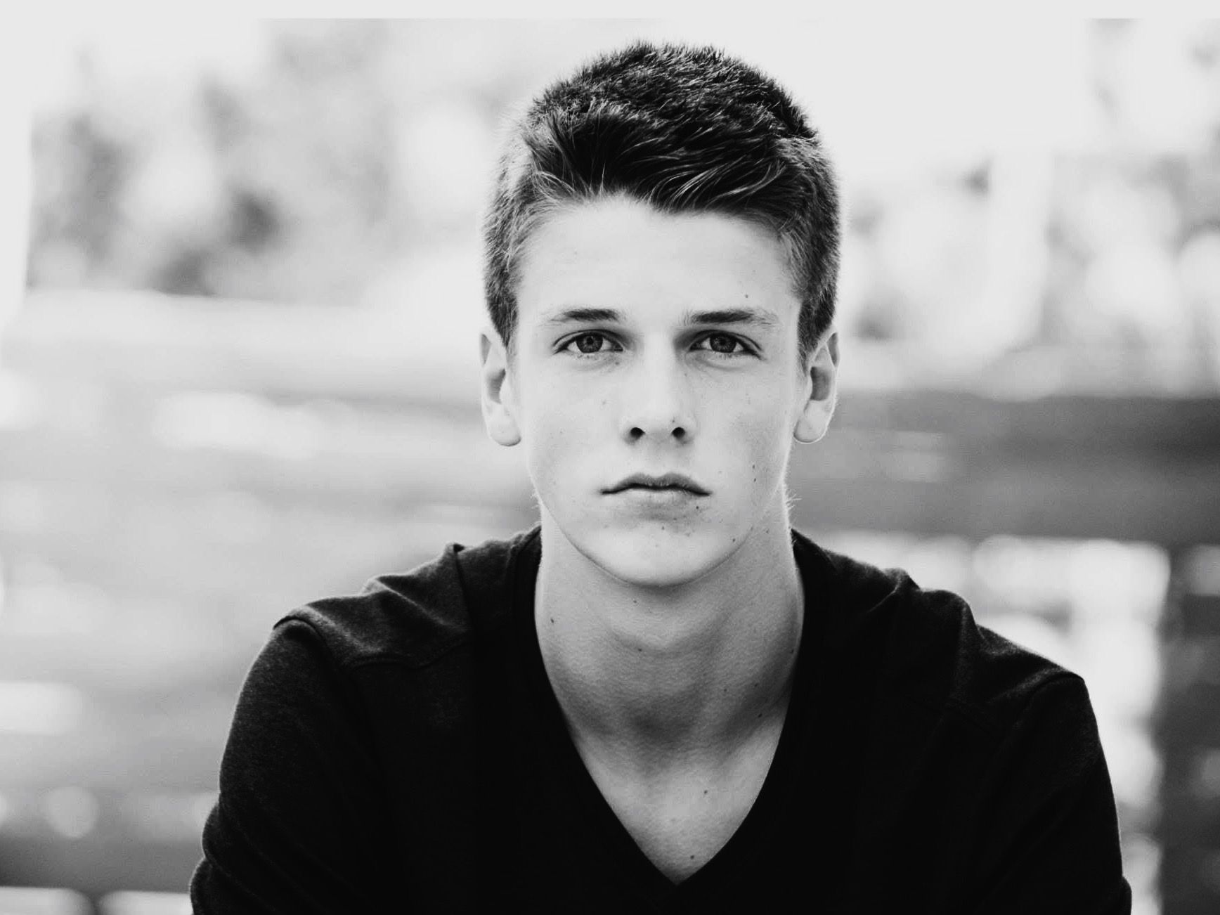 A black and white photo of a young man wearing a black shirt