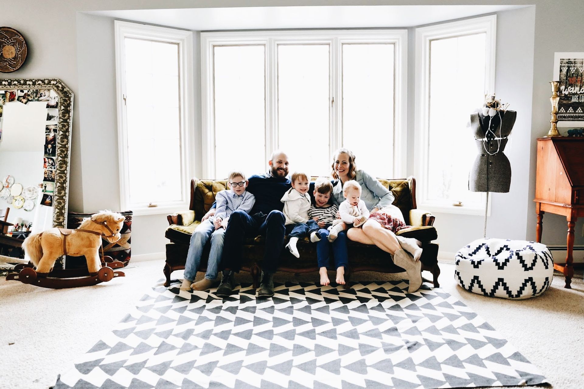 A family is sitting on a couch in a living room.