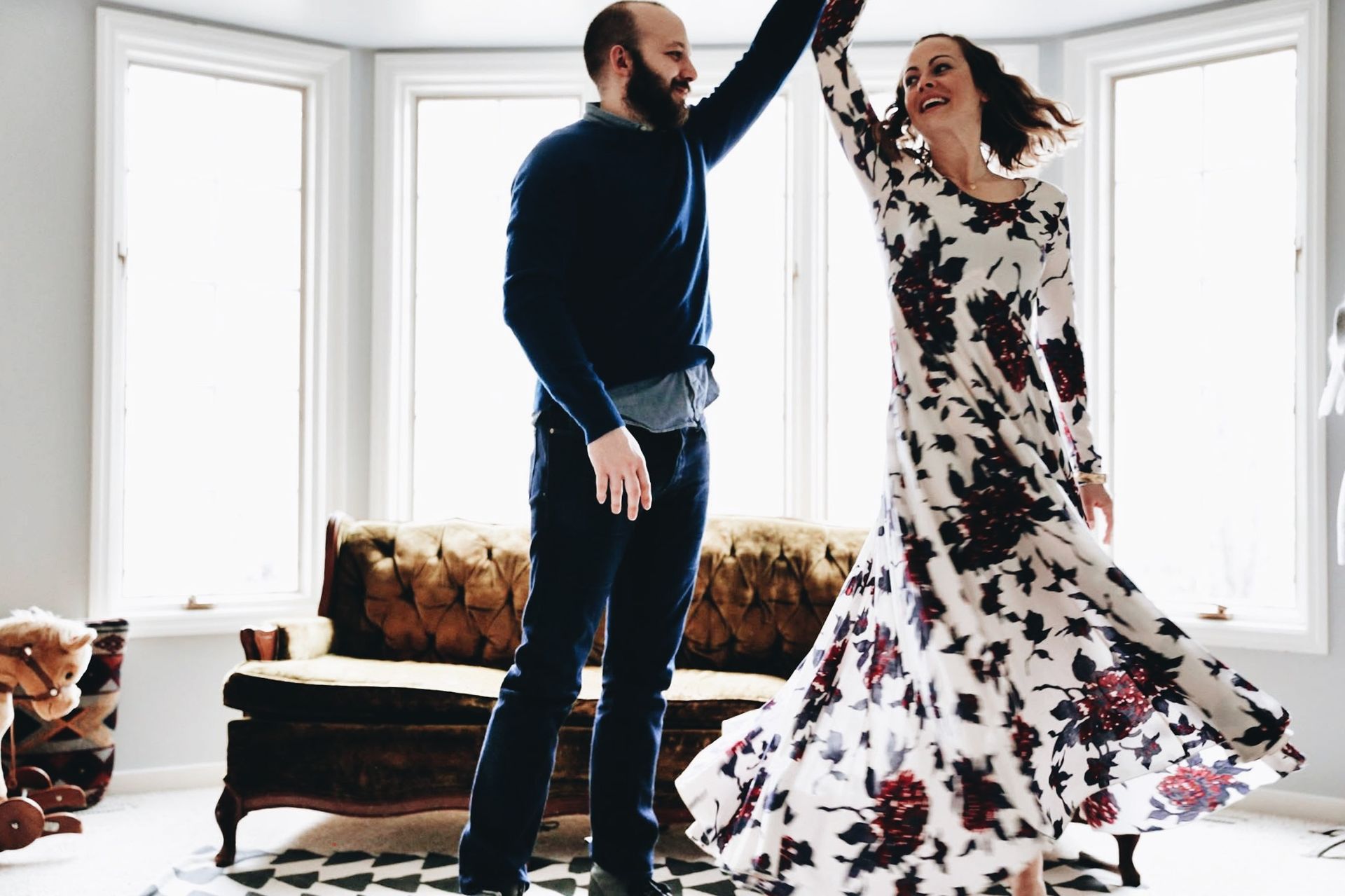 A man and a woman are dancing in a living room.