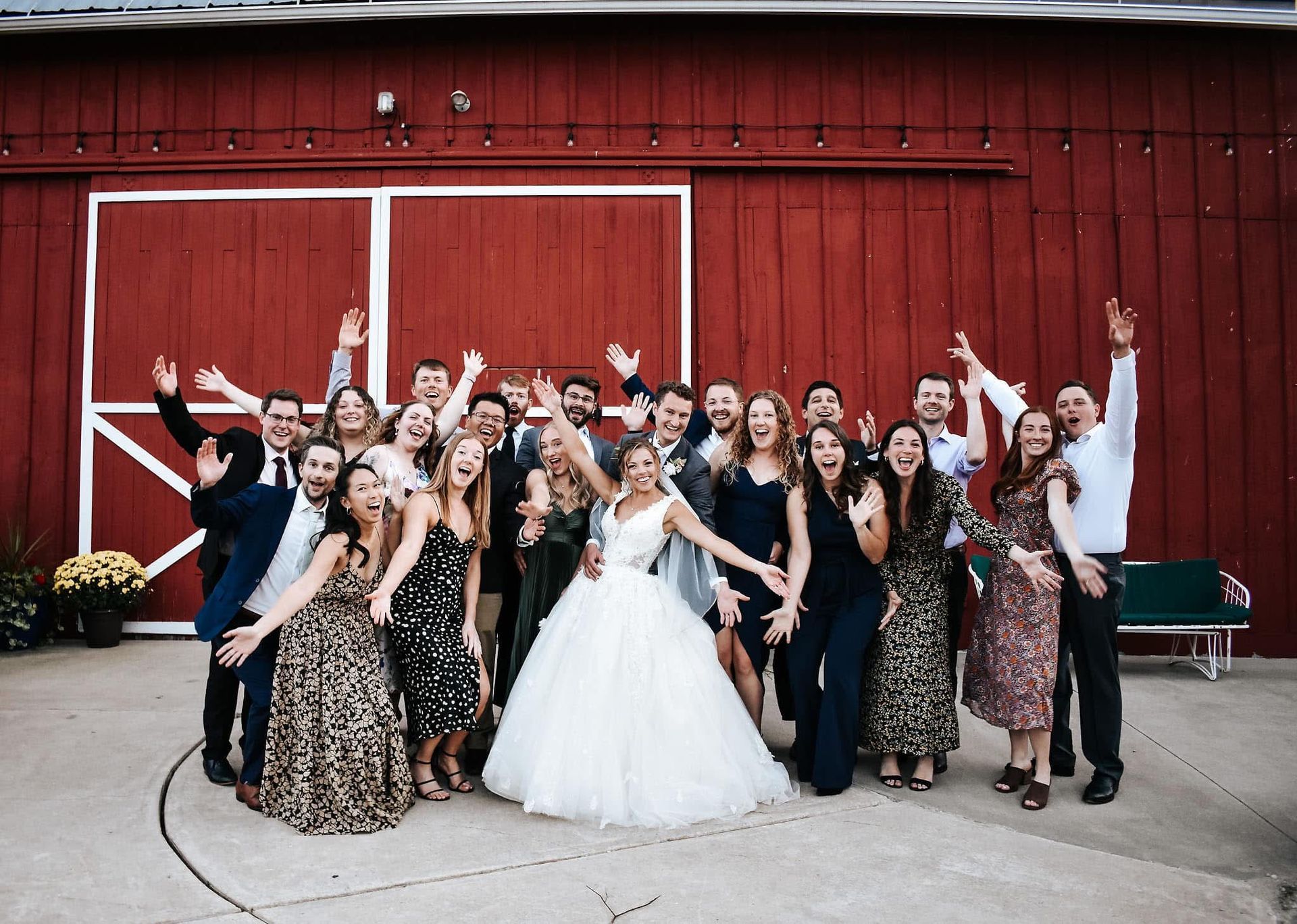 A large group of people are posing for a picture in front of a red barn.