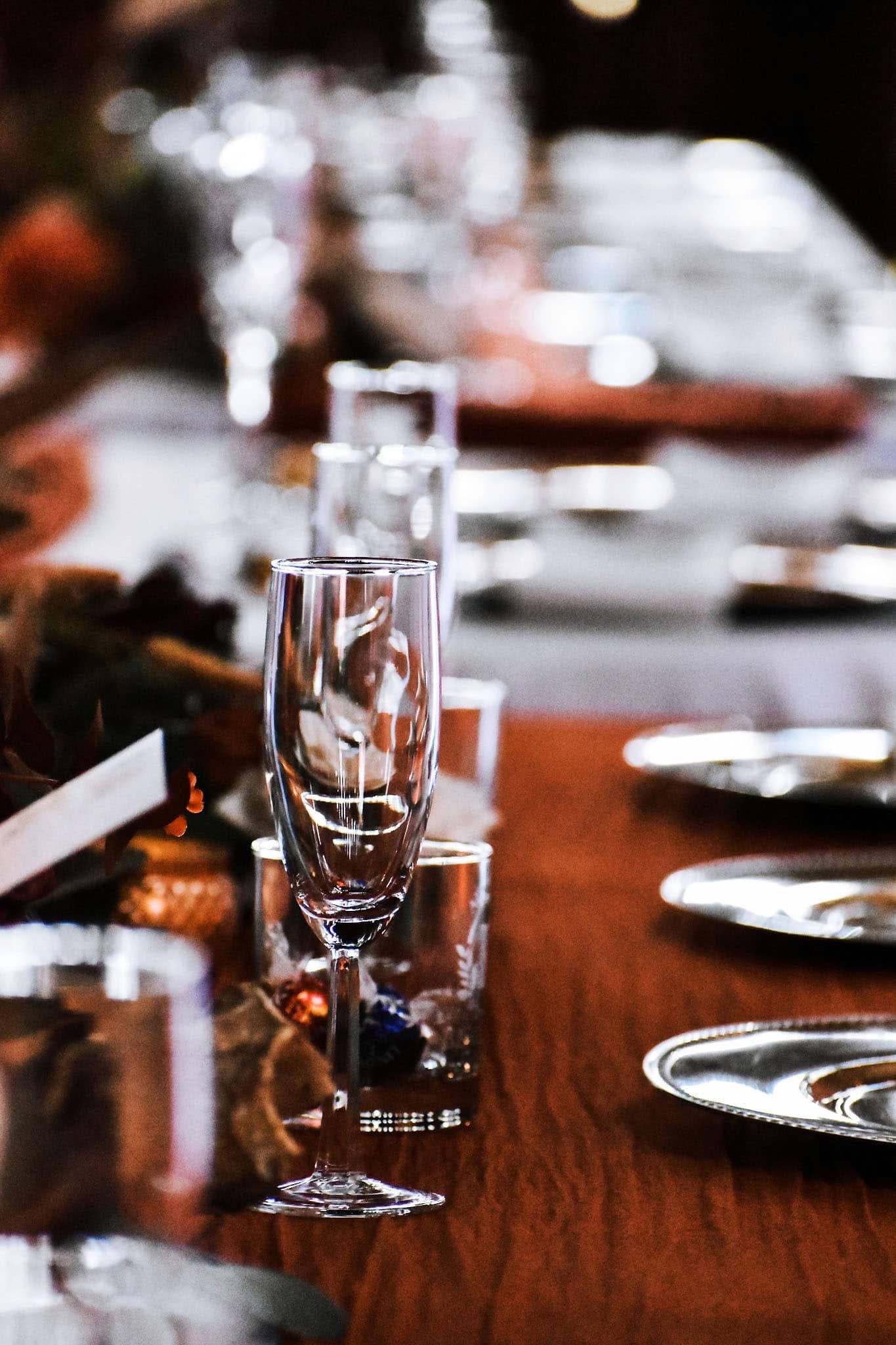 A row of wine glasses sitting on top of a wooden table.