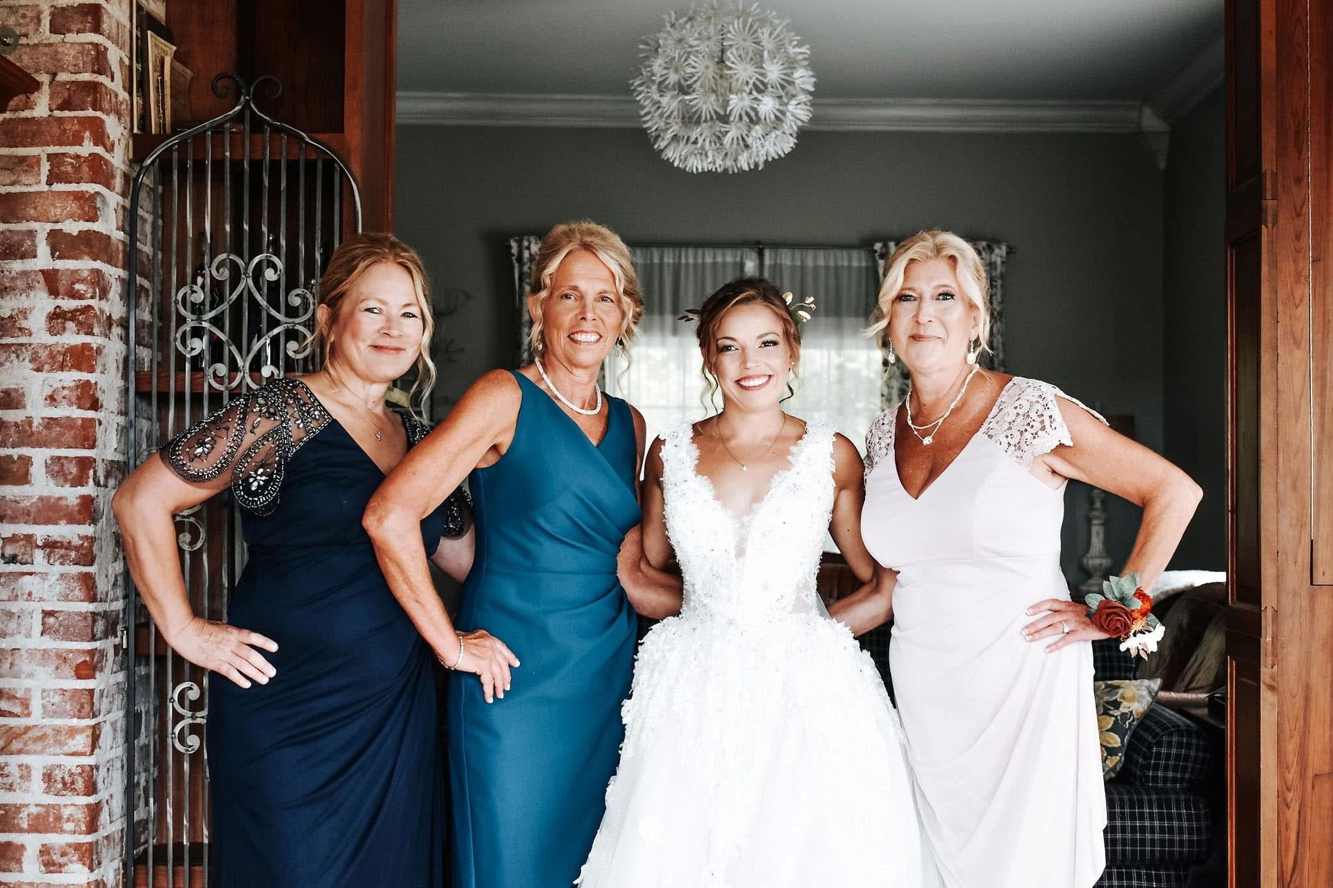 A bride and her mothers are posing for a picture.