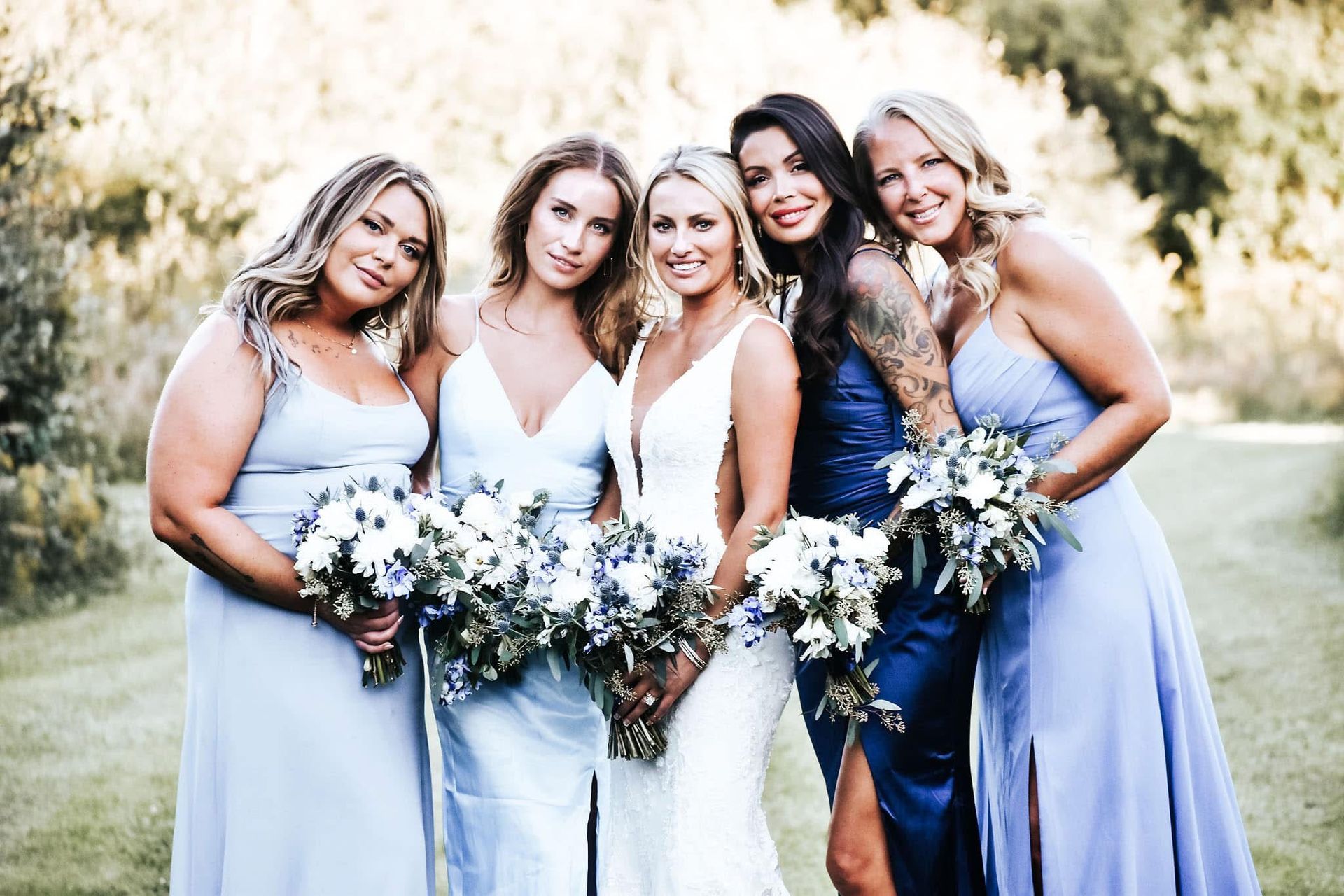A bride and her bridesmaids are posing for a picture together.