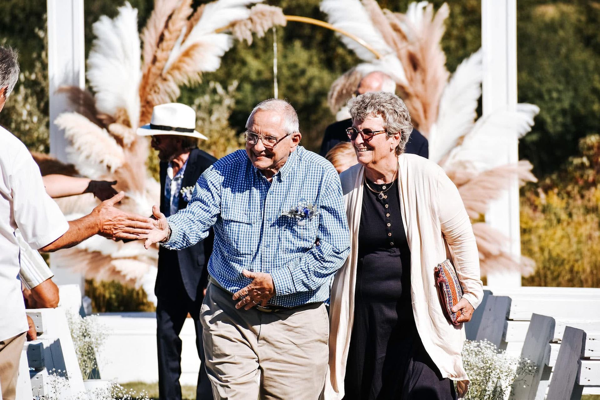 A man and a woman are walking down the aisle at a wedding.