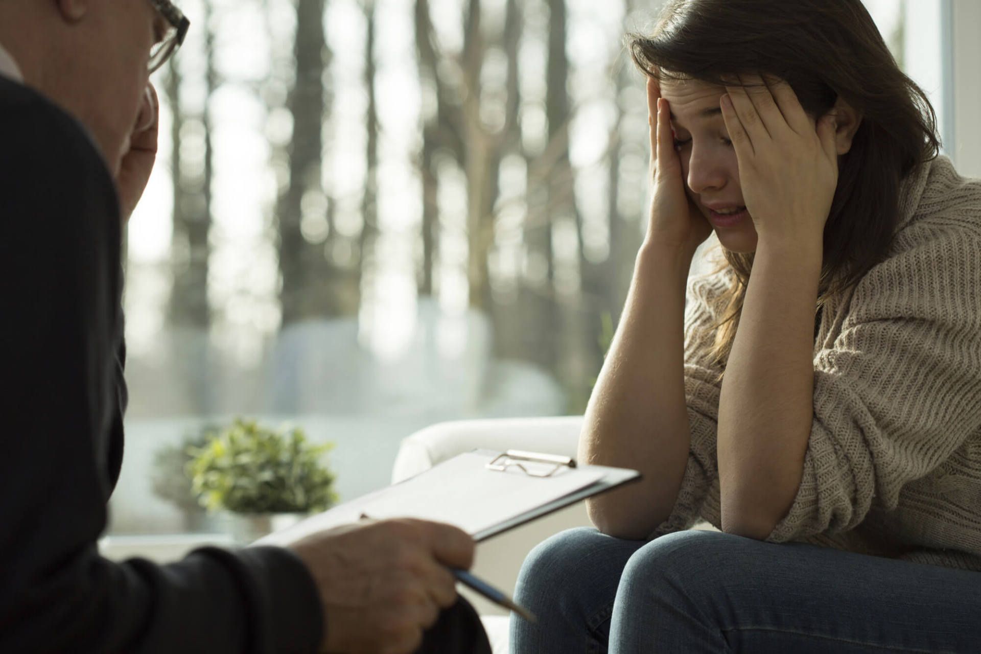 Distressed women with brown hair, talking to a therapist