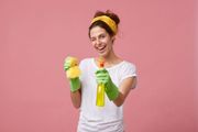 A woman is holding a spray bottle and a sponge.