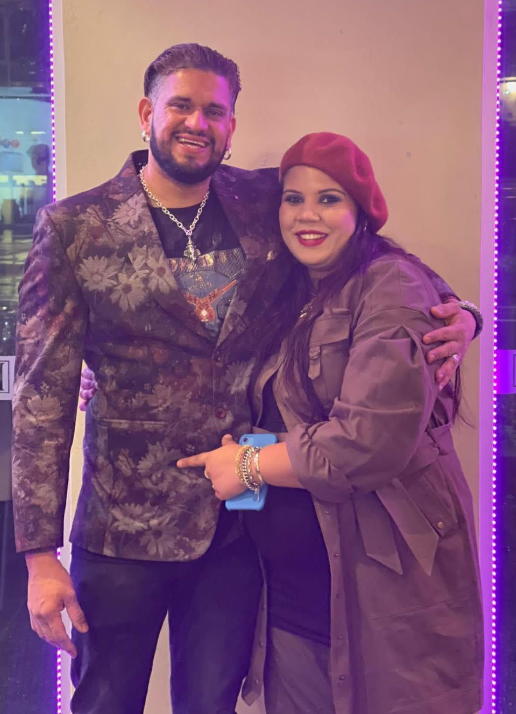 A man in a suit and a woman in a red beret pose for a picture