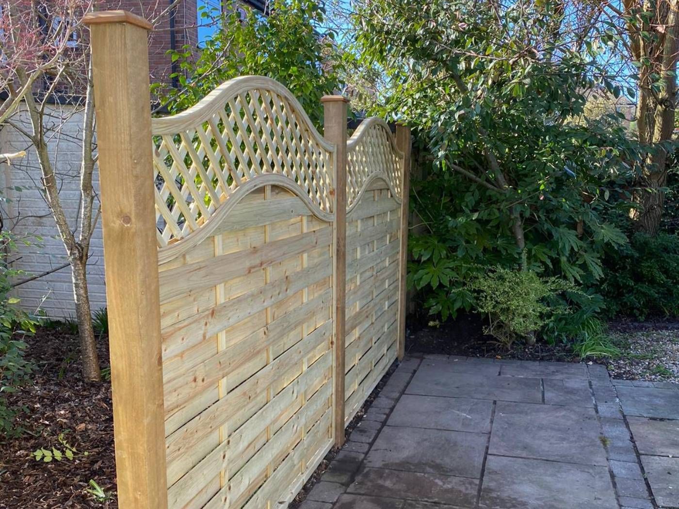 Arched trellis top fencing installed around a patio in Burton Joyce