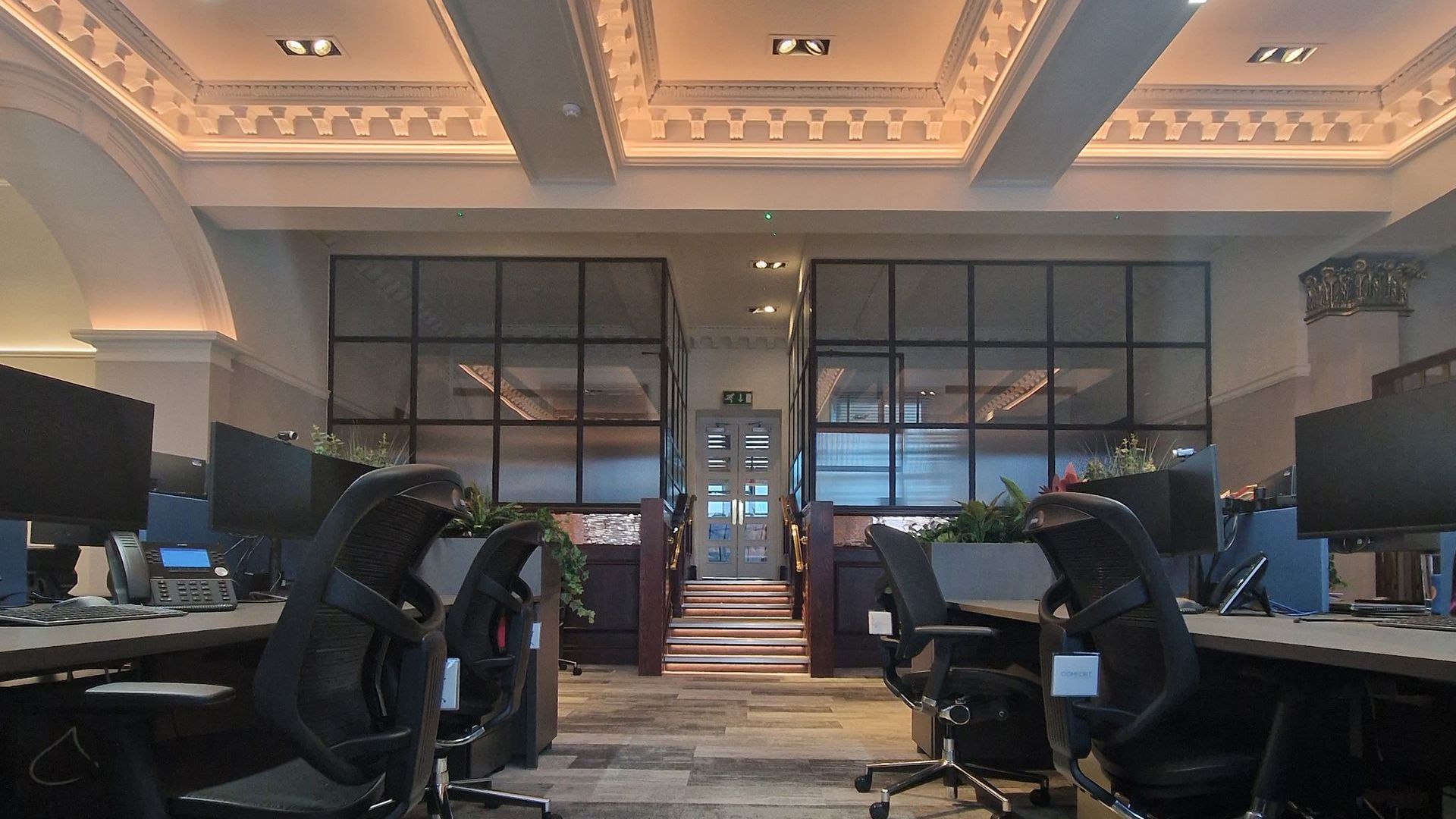 Office space at the William Duncan headquarters in Kilmarnock. It is an open space with bench desks and black ergonomic office chairs at each computer.