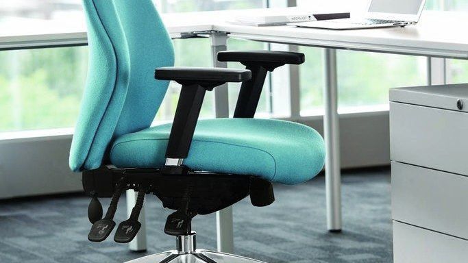 close up of the ocee four flexion seat in an aqua colour. the photo shows the comfortable seat and armrests. the chair is situated at a white desk. 
