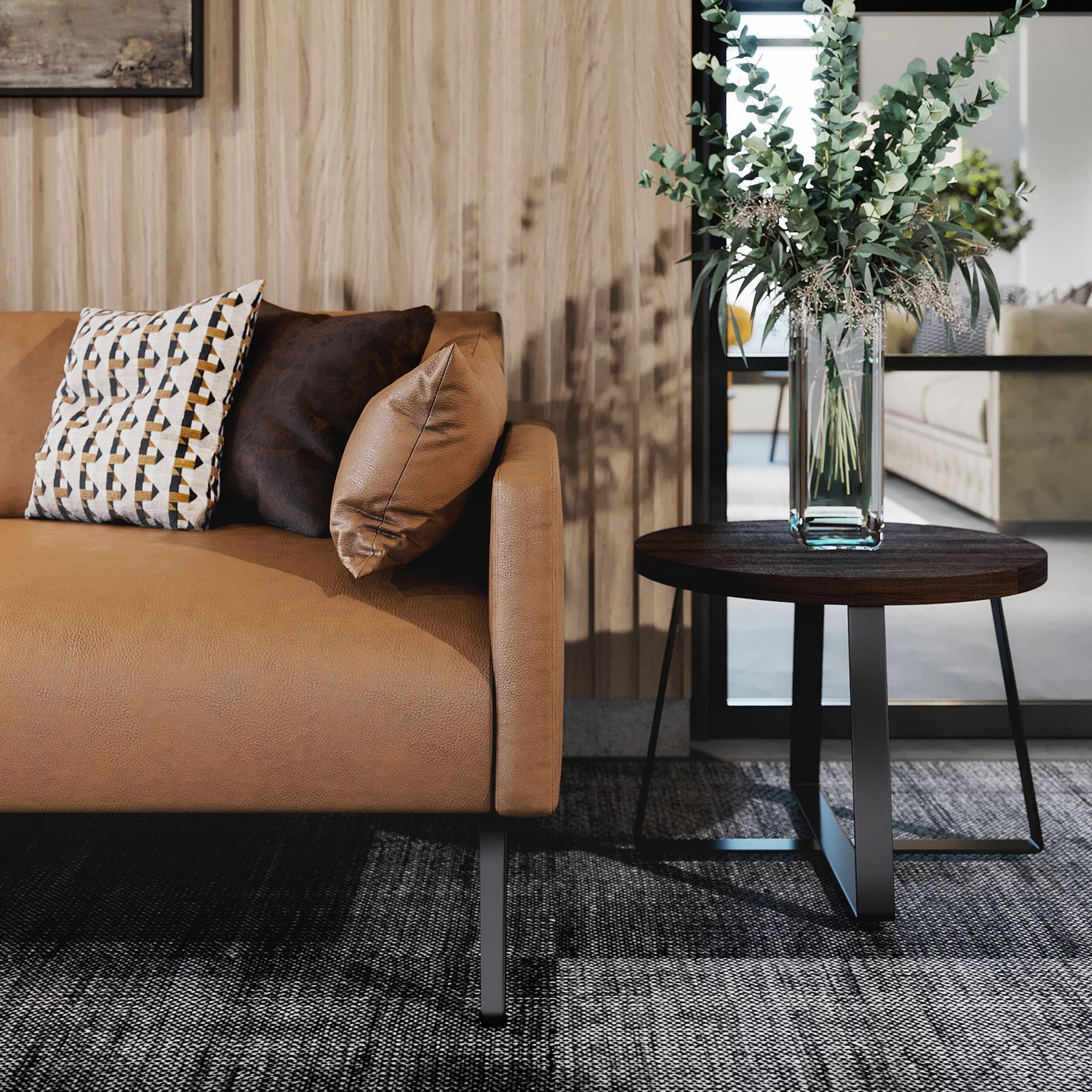 Tan sofa with pillows next to a small table with a vase of flowers.