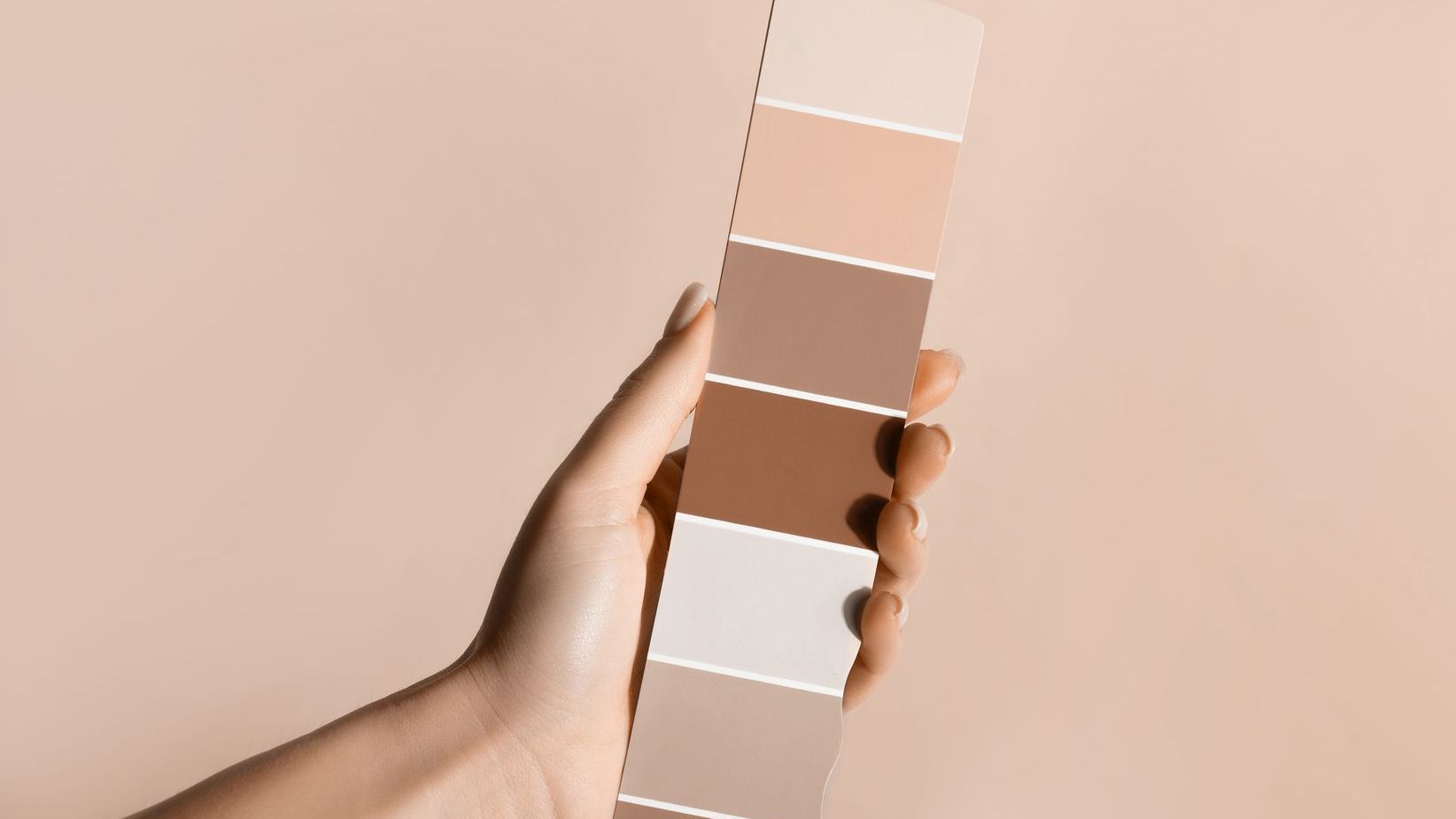 A person is holding a pantone color swatch in their hand