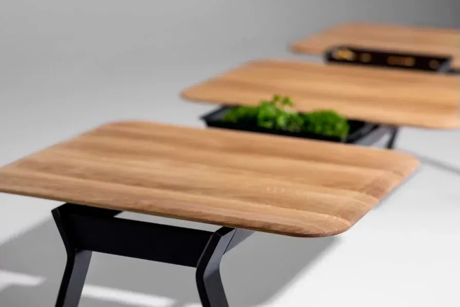 Close up of wooden table tops on black table legs.