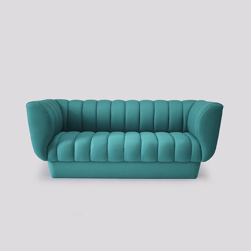 Teal tufted sofa with rounded arms on a light gray background.