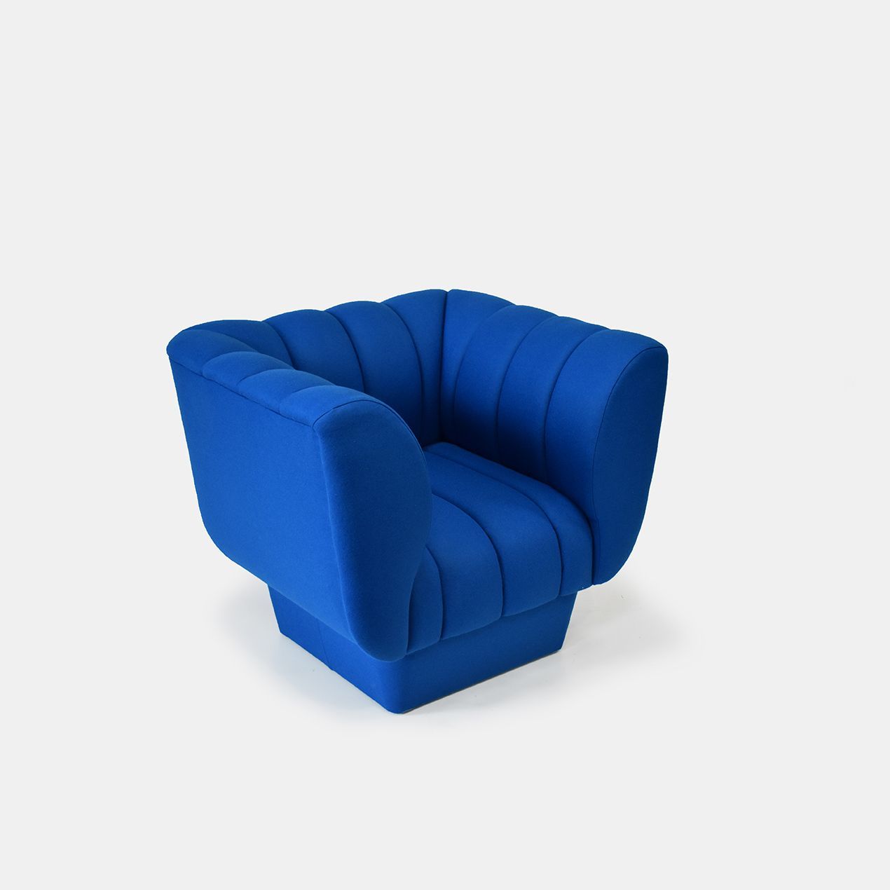 Blue upholstered armchair with fluted back and arms.