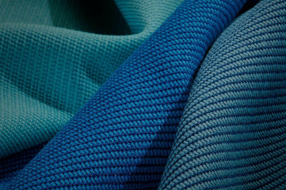 Close-up of textured blue fabric folds, ranging from teal to dark blue.