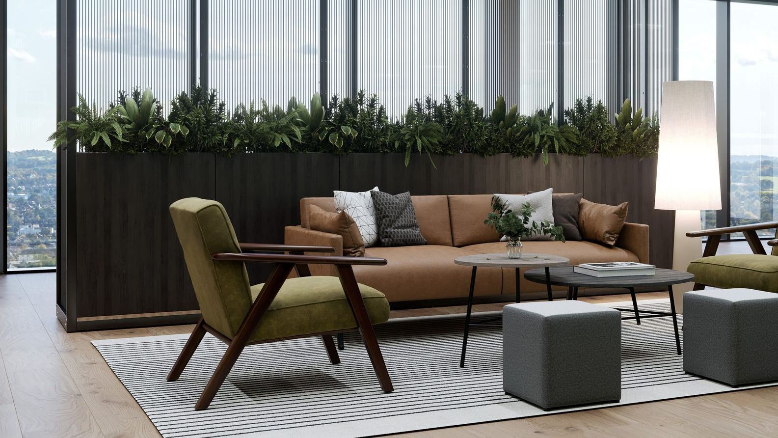 there is a brown sofa and a green armchair facing two coffee tables. the vibes of the office are organic and warm. behind the sofa is a divider with lush greenery. 