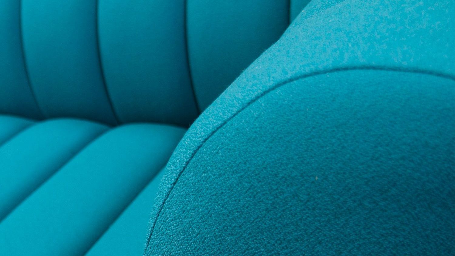 Close-up of teal, textured fabric with curved, cushioned lines.