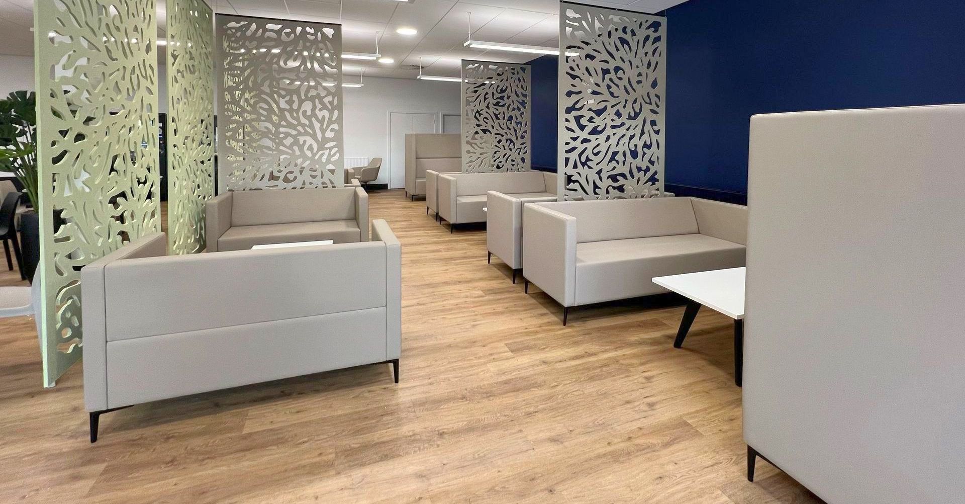 Autex acoustic ceiling-hung screens in a modern canteen space with soft seating, coffee table and planters,