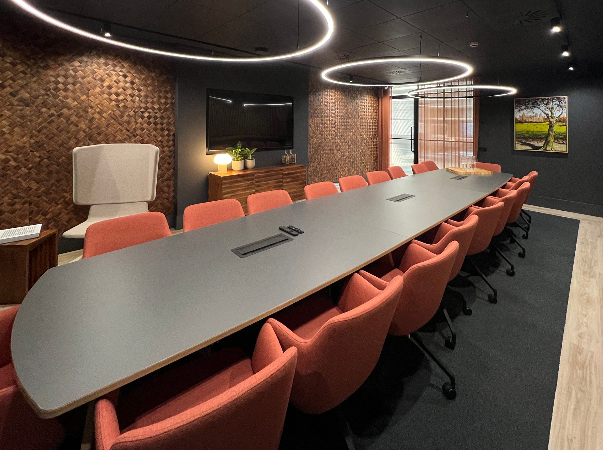 boardroom table with peachy orange armchairs surrounding it 