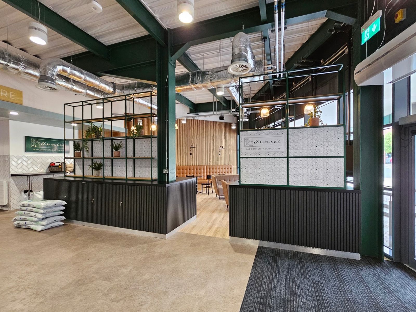 The photo focuses on large storage dividers that separate the cafe from the entryway. The dividers have shelving with space for plants, books, and other decor. 