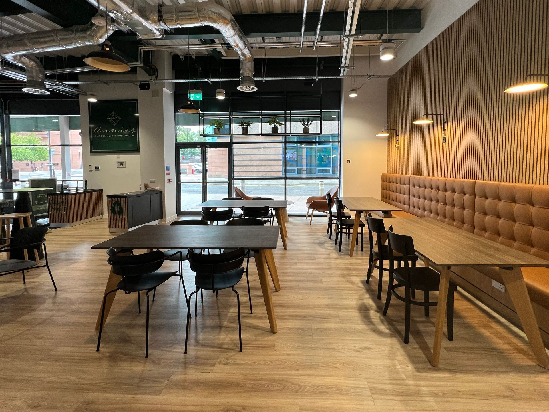 Larger tables available in Annie's Cafe, including light oak tables and dark wood. At each table is a mix of dining chairs, armchairs, and bench seating.