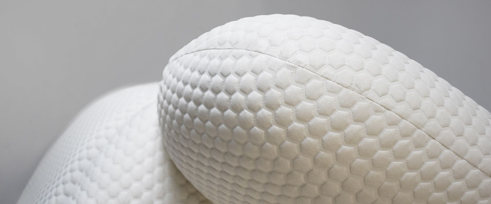 Close-up of a white pillow with a textured, honeycomb-like pattern.