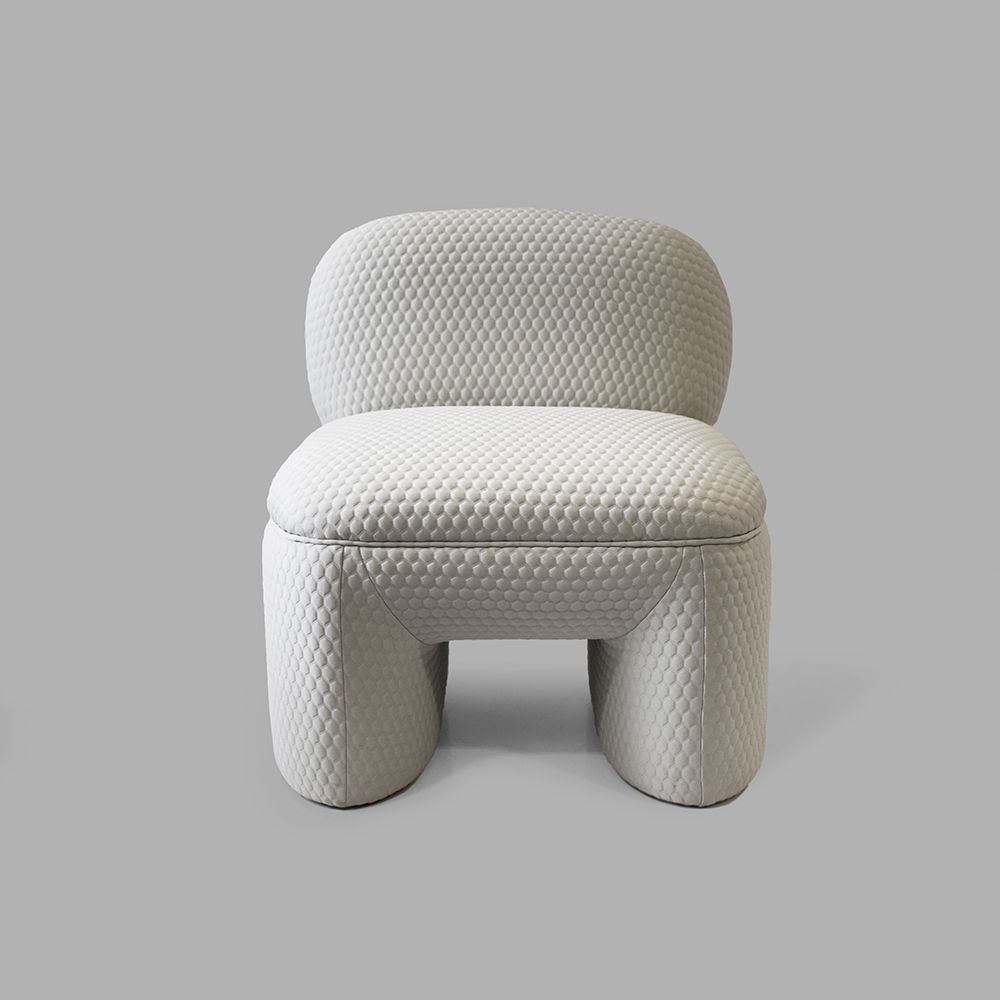 White upholstered armchair with textured fabric, on a gray background.