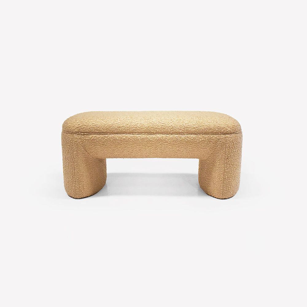 Beige boucle ottoman with rounded legs, against a white background.